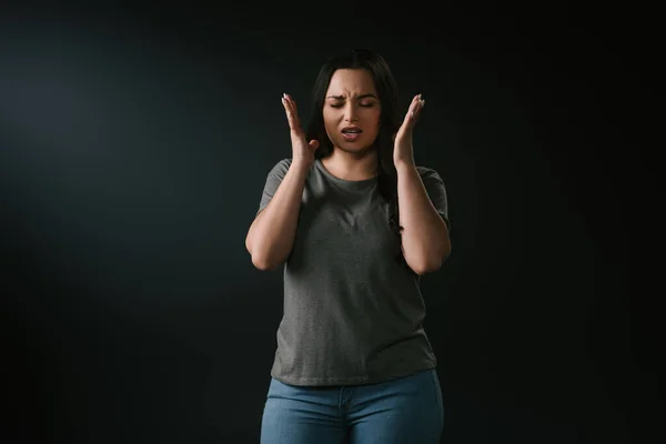 Front view of angry plus size girl gesturing on black background — Stock Photo