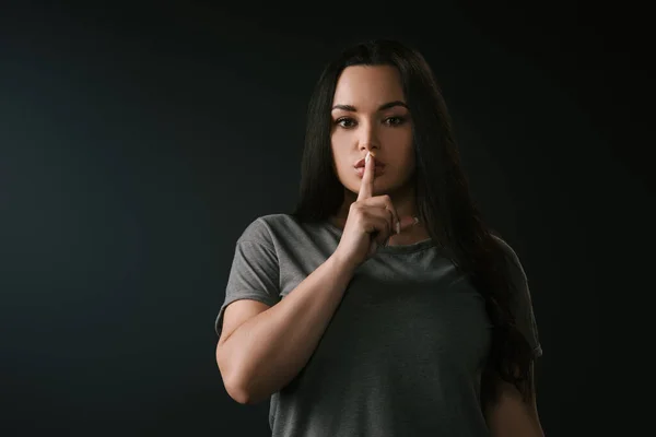 Vue de face de plus fille de taille avec geste de silence isolé sur noir — Photo de stock