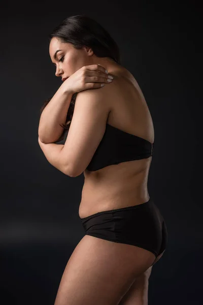 Side view of plus size girl in underware on black background — Stock Photo