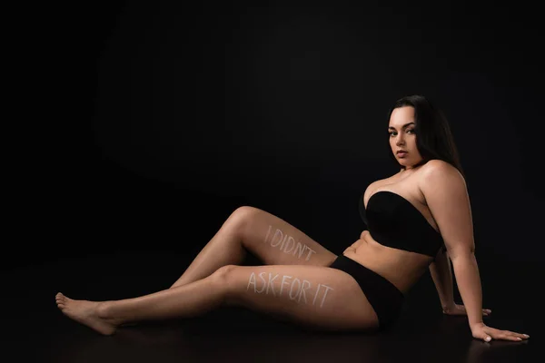 Side view of plus size model with lettering I Did not Ask For It on body on black background — Stock Photo