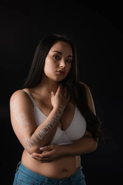 Half lenght vista di plus size modello in reggiseno bianco con scritte Violenza non è solo fisica a portata di mano isolato su nero — Foto stock