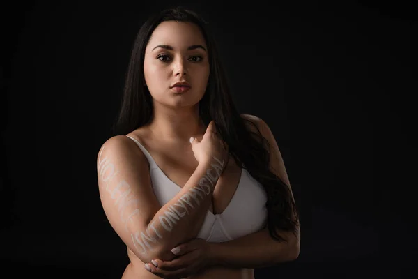 Beautiful plus size model covering bust with hand with lettering Violence Is not Only Physical isolated on black — Stock Photo