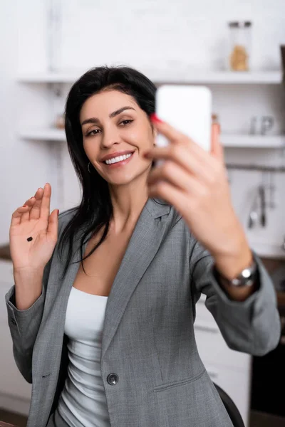 Selektive Fokussierung der fröhlichen Geschäftsfrau mit schwarzem Punkt auf das Selfie mit der Handfläche, Konzept häuslicher Gewalt — Stockfoto