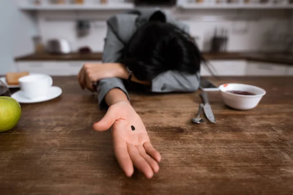 Foco seletivo de empresária mostrando mão com ponto preto na palma da mão enquanto cobre rosto, conceito de violência doméstica — Fotografia de Stock