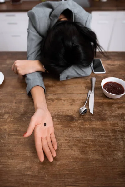 Empresária mostrando mão com ponto preto na palma da mão enquanto cobre rosto, conceito de violência doméstica — Fotografia de Stock