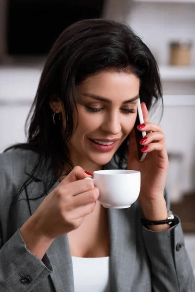 Businesswoman holding cup of coffee and talking on smartphone while hiding problem of domestic violence — Stock Photo