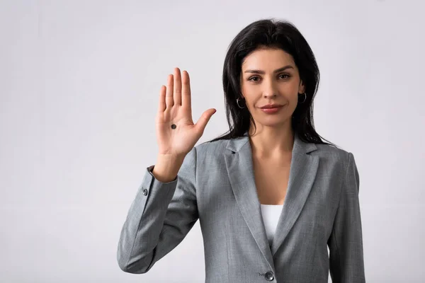 Femme d'affaires montrant la main avec un point noir sur la paume et debout sur blanc, concept de violence domestique — Photo de stock