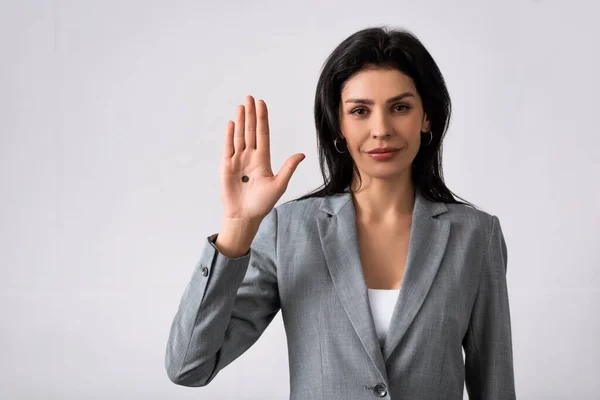 Empresaria mostrando la mano con el punto negro en la palma de la mano y de pie en blanco, concepto de violencia doméstica - foto de stock