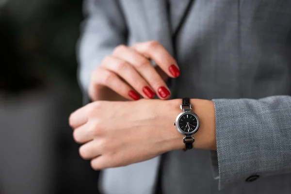 Vista recortada de la mujer de negocios con moretones en la mano toque reloj, concepto de violencia doméstica - foto de stock