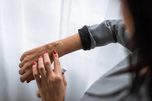 Вибірковий фокус ділової жінки, що застосовує основу макіяжу на руці з синяком, концепція домашнього насильства — стокове фото
