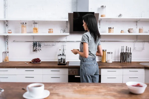 Selective focus of woman holding plate with toast bread and standing in kitchen — Stock Photo