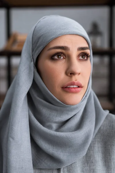 Mujer musulmana disgustada en hijab mirando hacia arriba, concepto de violencia doméstica - foto de stock