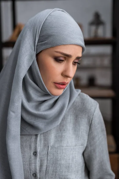 Mujer musulmana triste en hijab mirando hacia abajo, concepto de violencia doméstica - foto de stock