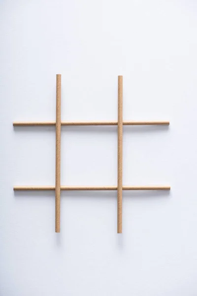 Top view of grid made of paper tubes for tic tac toe game on white surface — Stock Photo