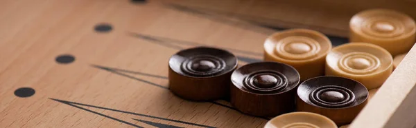 KYIV, UKRAINE - JANUARY 30, 2019: panoramic shot of wooden checkers on backgammon board — Stock Photo