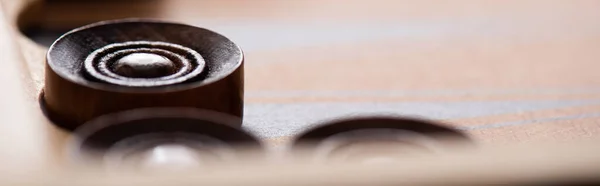 KYIV, UKRAINE - JANUARY 30, 2019: selective focus of wooden checkers on backgammon board, panoramic shot — Stock Photo