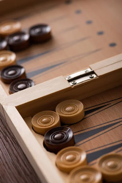 KYIV, UKRAINE - JANUARY 30, 2019: selective focus of backgammon board with checkers on wooden surface — Stock Photo