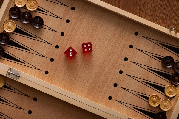 KYIV, UKRAINE - JANUARY 30, 2019: top view of wooden backgammon board with checkers and dice pair — Stock Photo