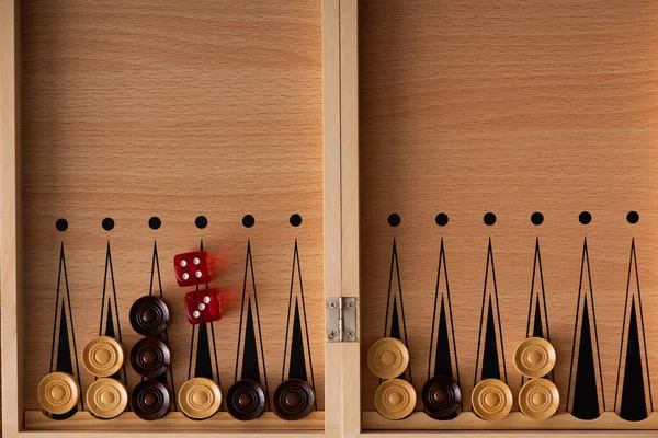 KYIV, UKRAINE - JANUARY 30, 2019: top view of wooden backgammon board with dice pair and checkers — Stock Photo