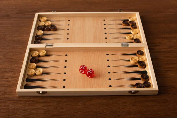 KYIV, UKRAINE - JANUARY 30, 2019: backgammon board with checkers and dice pair on wooden table — Stock Photo