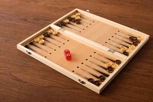 KYIV, UKRAINE - JANUARY 30, 2019: backgammon board with checkers and dice pair on wooden table — Stock Photo