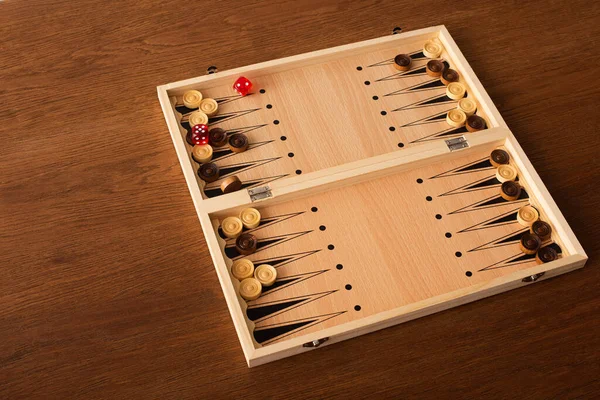 KYIV, UKRAINE - JANUARY 30, 2019: backgammon board with checkers and dice pair on wooden table — Stock Photo