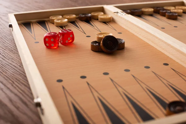 KYIV, UKRAINE - JANUARY 30, 2019: selective focus of backgammon board with checkers and dice pair on wooden table — Stock Photo