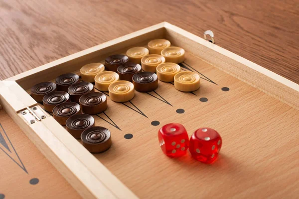 KYIV, UKRAINE - JANUARY 30, 2019: backgammon board with checkers and dice pair on wooden table — Stock Photo