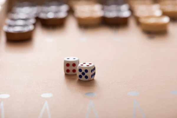 QUIIV, UCRÂNIA - JANEIRO 30, 2019: foco seletivo de par de dados perto de damas no tabuleiro de gamão — Fotografia de Stock