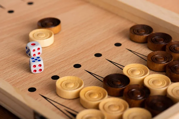 KYIV, UCRANIA - 30 DE ENERO DE 2019: enfoque selectivo del tablero de backgammon de madera con damas y pares de dados - foto de stock