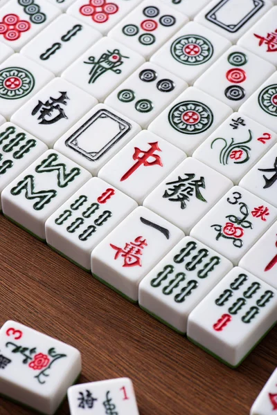 KYIV, UCRANIA - 30 de enero de 2019: campo de azulejos del juego de mahjong con signos y personajes en la mesa de madera - foto de stock