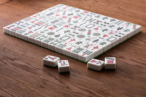 KYIV, UKRAINE - 30 JANVIER 2019 : champ de tuiles de jeu de mahjong blanc avec signes et personnages sur table en bois — Photo de stock