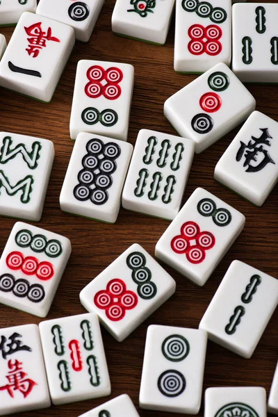 KYIV, UKRAINE - JANUARY 30, 2019: top view of white mahjong game tiles with signs and characters on wooden table — Stock Photo