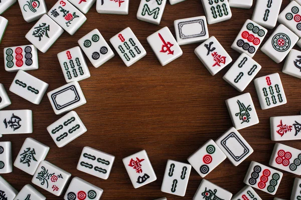 KYIV, UKRAINE - 30 JANVIER 2019 : cadre de tuiles de jeu de mahjong blanc sur table en bois, vue du dessus — Photo de stock