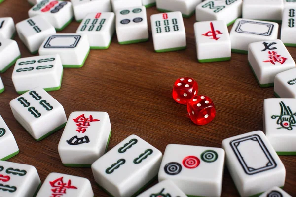 KYIV, UKRAINE - 30 JANVIER 2019 : carreaux de jeu de mahjong blanc et paire de dés sur table en bois — Photo de stock