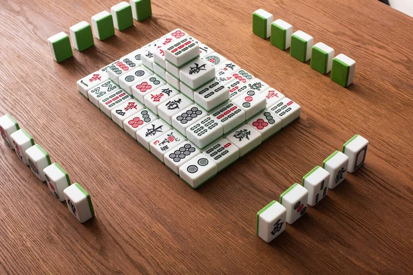 KIEW, UKRAINE - 30. JANUAR 2019: Reihen und Pyramide aus Mahjong-Spielsteinen auf Holztisch — Stockfoto