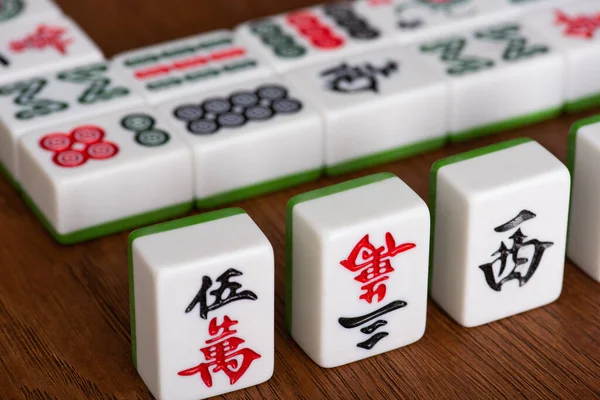 KYIV, UKRAINE - JANUARY 30, 2019: selective focus of mahjong game tiles on wooden table — Stock Photo