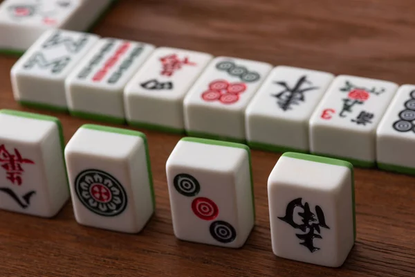 KYIV, UKRAINE - JANUARY 30, 2019: selective focus of white mahjong game tiles on wooden surface — Stock Photo