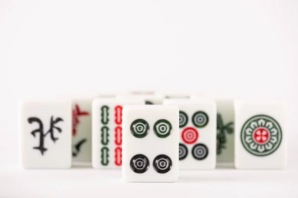 KYIV, UCRANIA - 30 de enero de 2019: enfoque selectivo de las fichas del juego de mahjong con signos y personajes sobre fondo blanco con espacio para copiar - foto de stock
