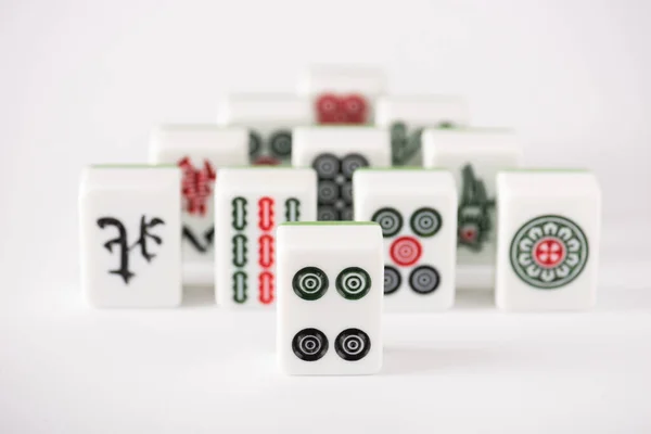 KYIV, UCRANIA - 30 de enero de 2019: enfoque selectivo de las fichas del juego de mahjong con signos y personajes sobre fondo blanco - foto de stock