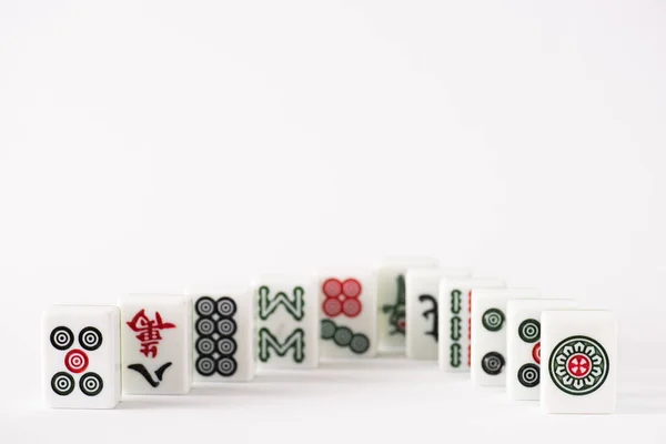 KYIV, UCRANIA - 30 de enero de 2019: enfoque selectivo de las fichas del juego de mahjong con signos y personajes sobre fondo blanco con espacio para copiar - foto de stock