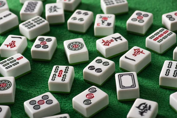 KYIV, UKRAINE - JANEIRO 30, 2019: foco seletivo de azulejos de jogo mahjong brancos com sinais e símbolos na superfície de veludo verde — Fotografia de Stock