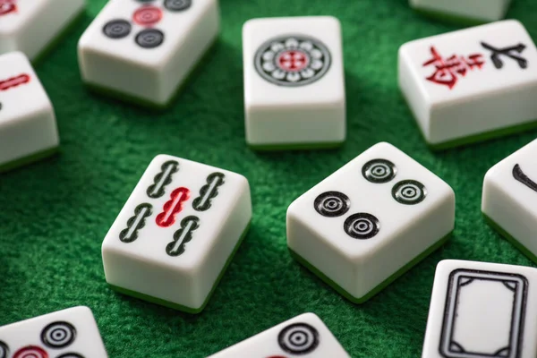 KYIV, UKRAINE - JANEIRO 30, 2019: foco seletivo de azulejos de jogo mahjong brancos com sinais e símbolos na superfície de veludo verde — Fotografia de Stock