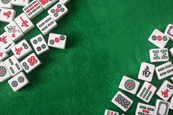 KYIV, UCRANIA - 30 de enero de 2019: vista superior de las fichas de mahjong blanco con signos y personajes en la superficie de terciopelo verde - foto de stock