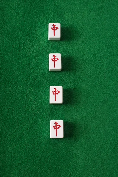 KYIV, UKRAINE - JANUARY 30, 2019: top view of mahjong game tiles row with characters on green velour surface — Stock Photo