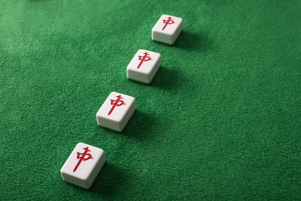 KYIV, UKRAINE - 30 JANVIER 2019 : rangée de tuiles de jeu de mahjong avec des personnages sur la surface de velours vert — Photo de stock