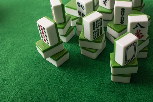 QUIIV, UCRÂNIA - JANEIRO 30, 2019: pilhas de telhas de jogo de mahjong na superfície de veludo verde — Fotografia de Stock
