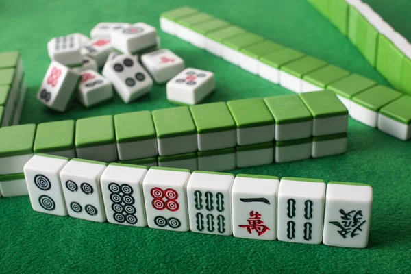 KYIV, UKRAINE - JANEIRO 30, 2019: foco seletivo de linhas e pilha de telhas de jogo mahjong na superfície de veludo verde — Fotografia de Stock