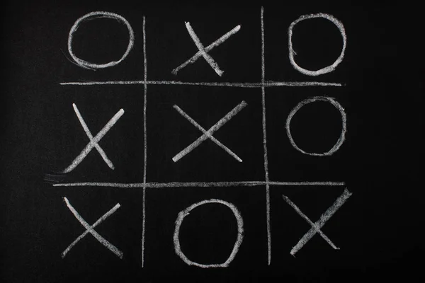 Tic-Tac-Toe-Spiel von oben auf Tafel mit Kreidenraster, Nullen und Kreuzen — Stockfoto