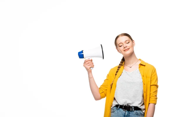 Smiling pretty girl with braid and closed eyes holding loudspeaker near ear isolated on white — Stock Photo